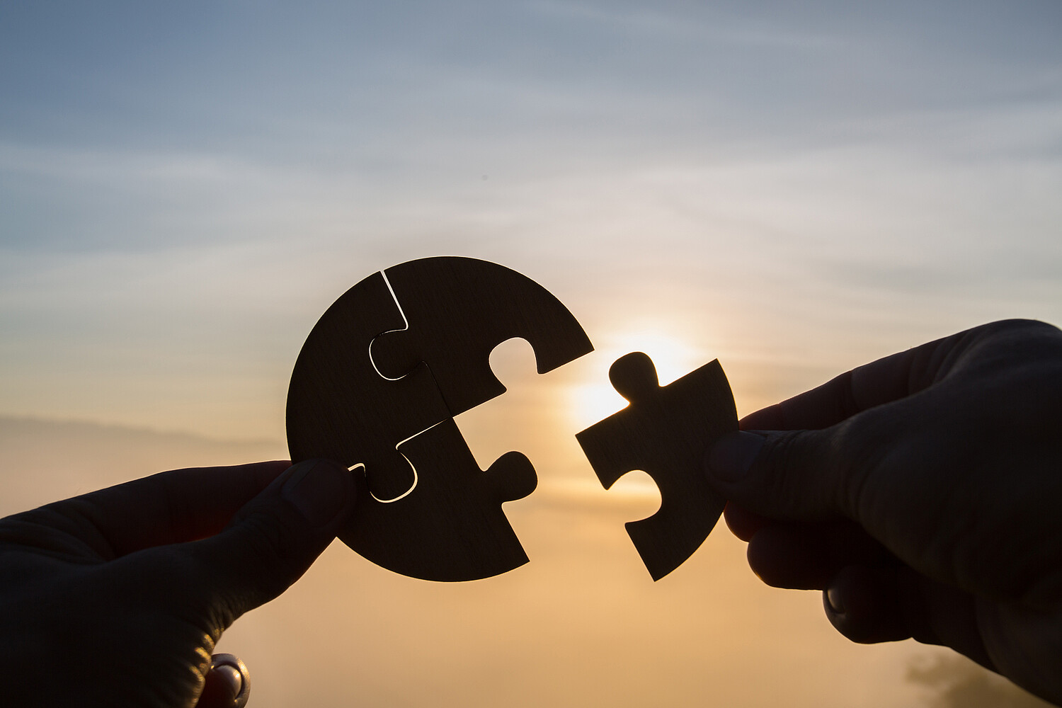 Silhouette Woman hands connecting couple puzzle piece against sunrise, Business solutions, target, success, goals and strategy concepts Silhouette Woman hands connecting couple puzzle piece against sunrise, Business solutions, target, success, goals and strategy concepts